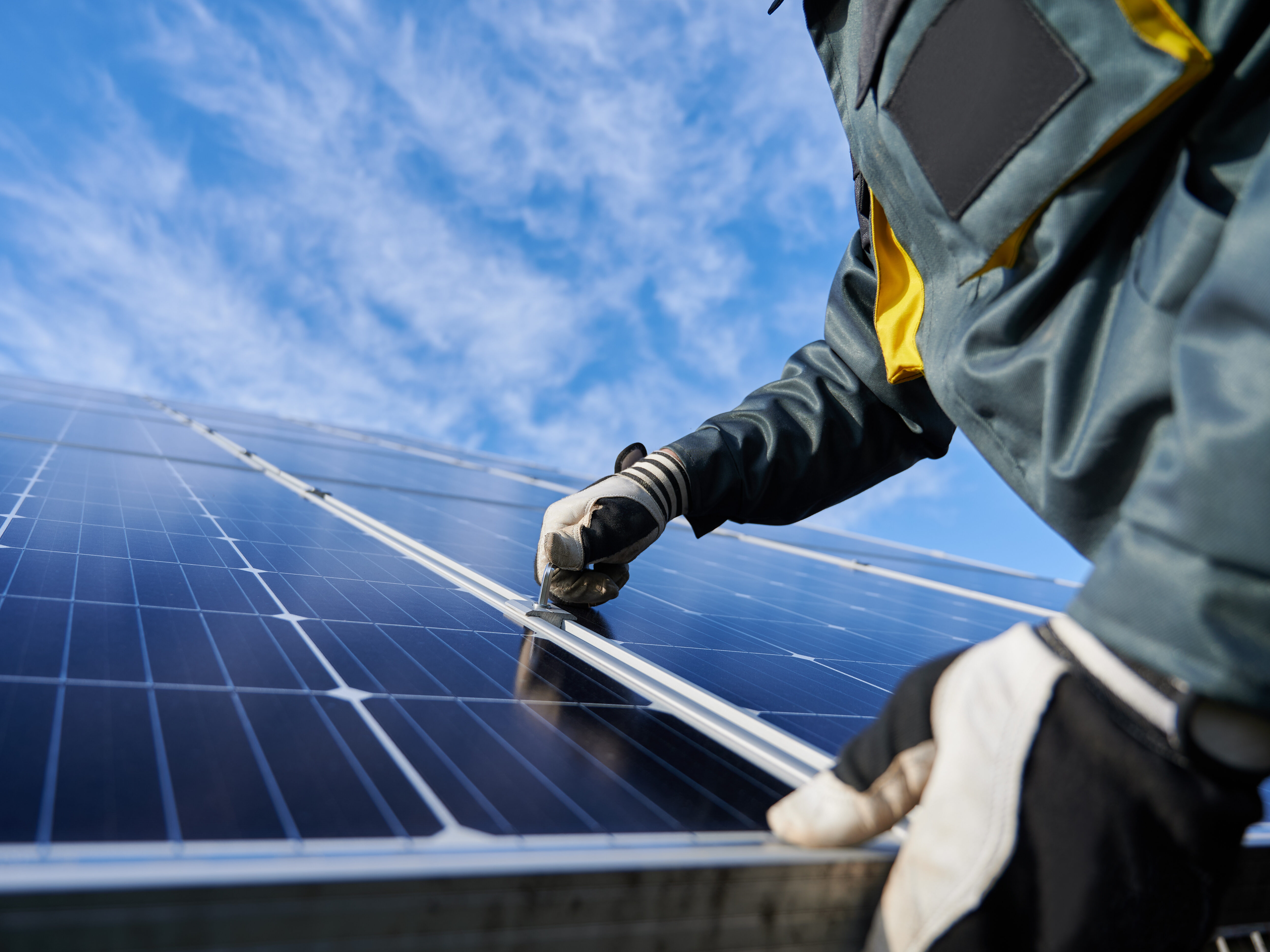 Male worker repairing photovoltaic solar panel.