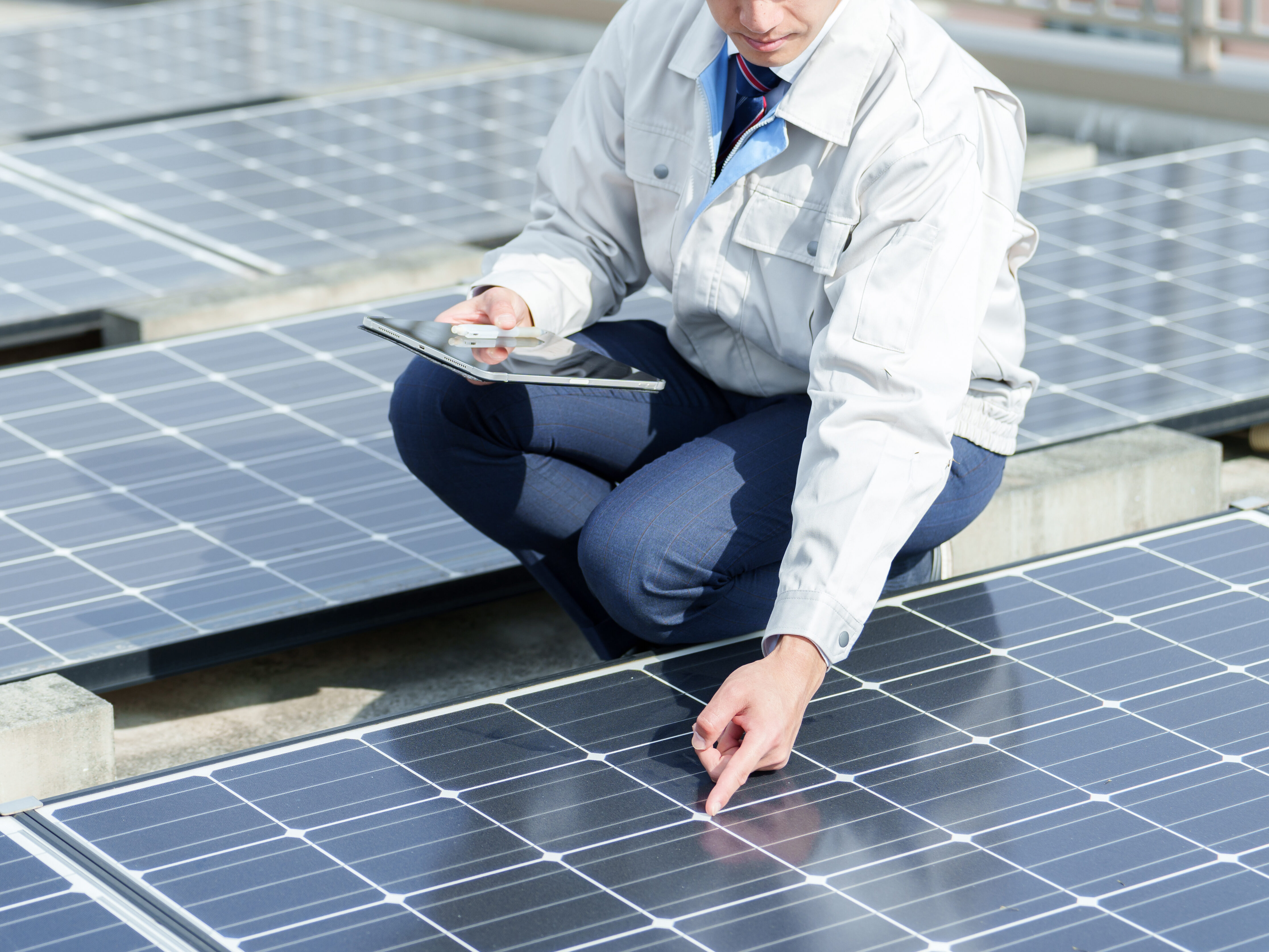 ソーラーパネルのメンテナンスをする男性技術